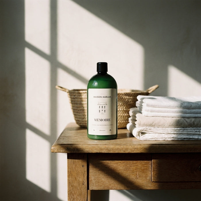 MÉMOIRE bottle on an oak table, basket and towels