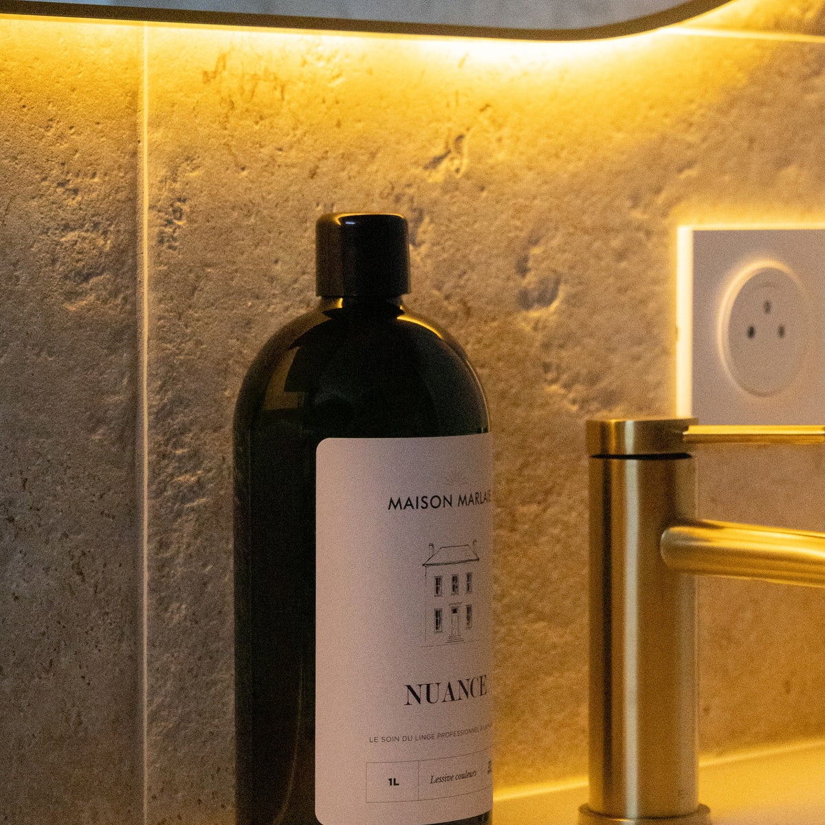 Maison Marlaie NUANCE bottle by a stone basin and a brass tap
