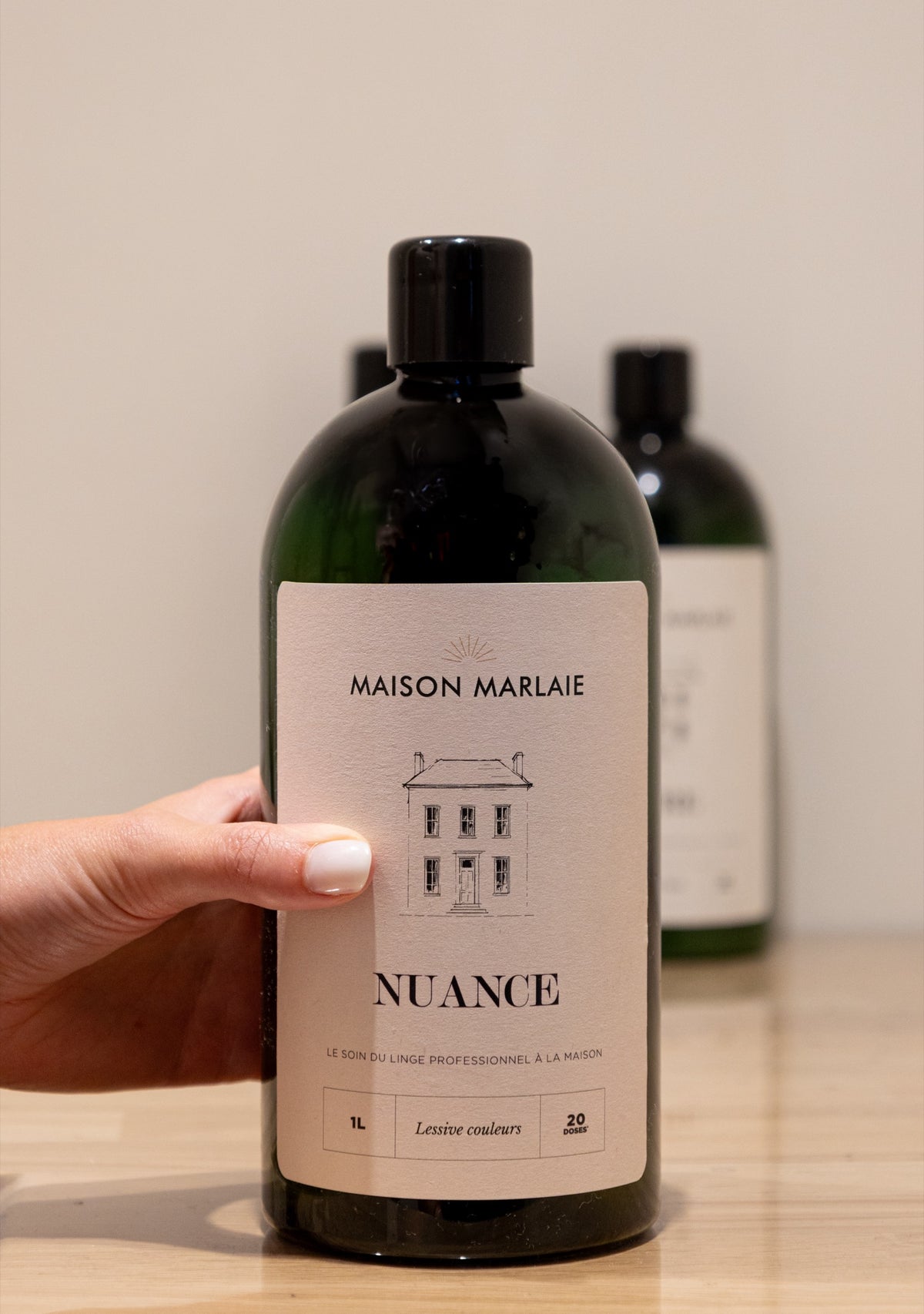 Maison Marlaie NUANCE bottle in the light, on a wooden panel